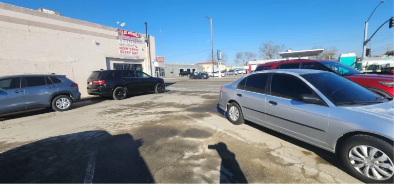Cars parked in a cracked lot.