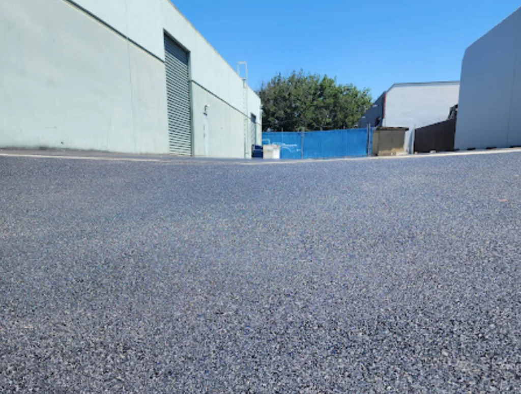 Asphalt Paving 3 Empty asphalt area with buildings nearby.