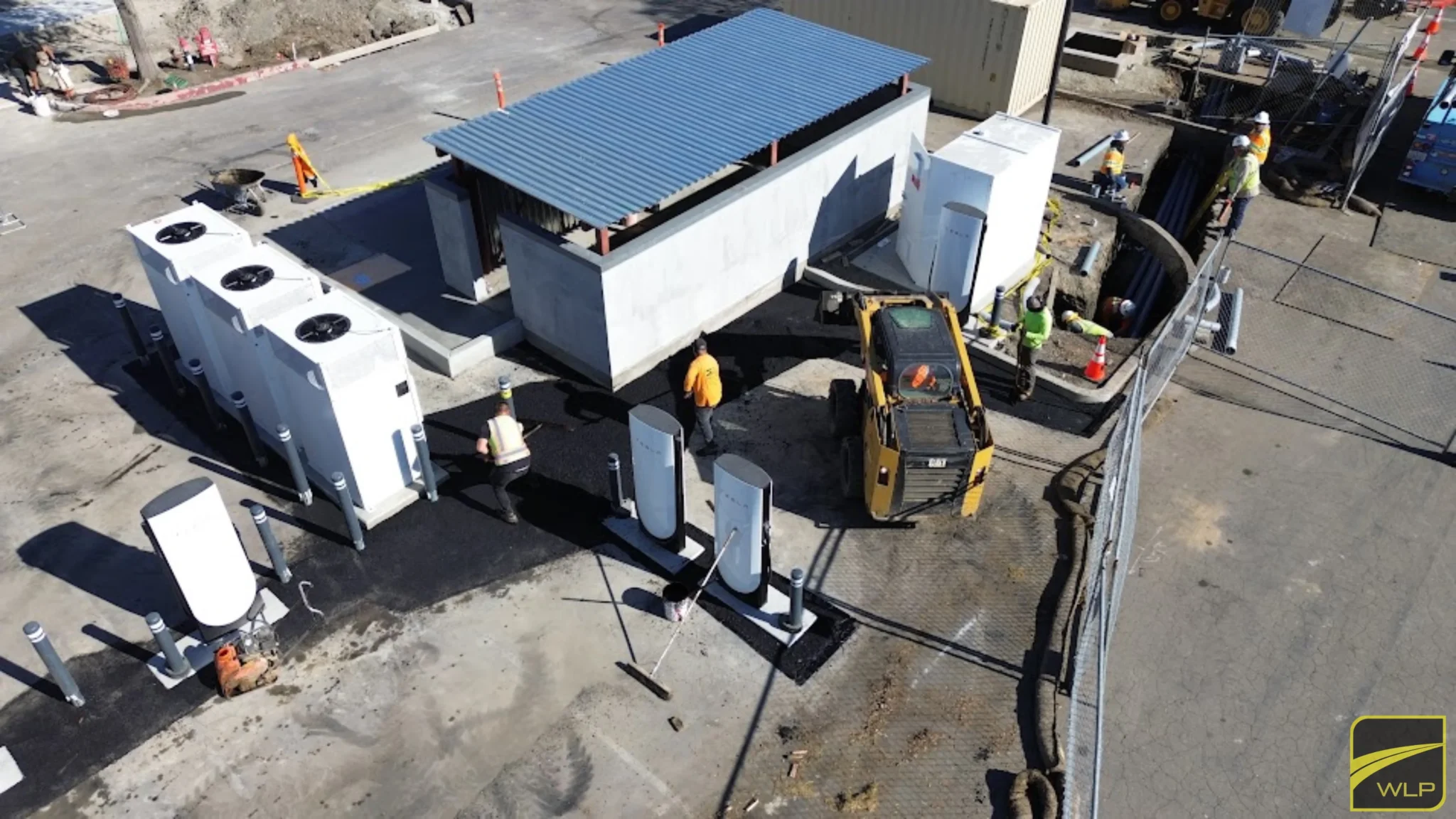 EV Charging Station Construction 2 A yellow skid steer loader spreading fresh black asphalt at a Tesla charging site in Tracy. Project by We Love Paving in Northern California, CA.