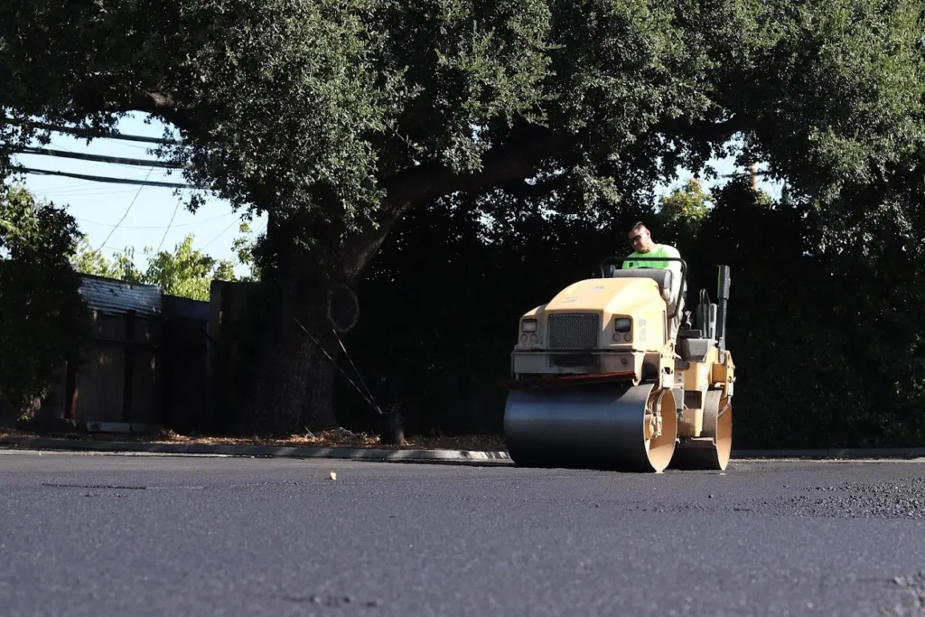 Ada Apartment 1 A worker operating a yellow steam roller to compact fresh asphalt on a new road in Corte Madera. Project by We Love Paving in Corte Madera, CA.
