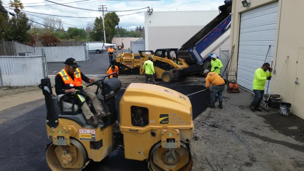 Asphalt Paving 3 Workers paving asphalt near building.