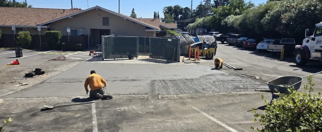 Pouring Concrete Near Property Lines: Legal Distances and Regulations 2 Workers smoothing fresh concrete during a parking lot repair project in Marin, California. Project by We Love Paving in Marin, CA.