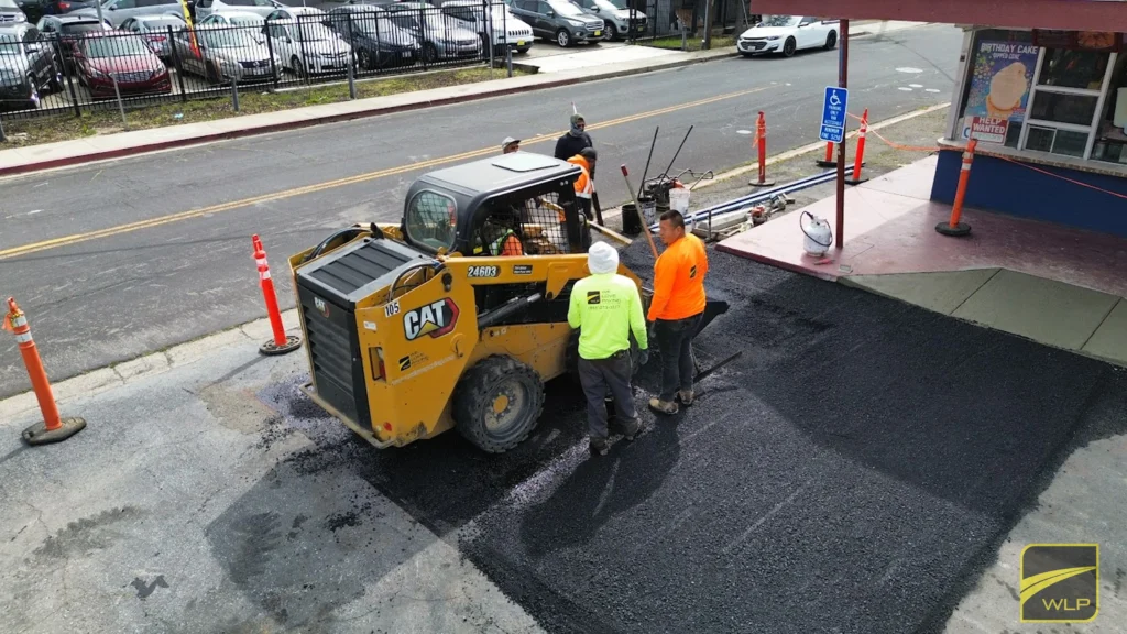 Asphalt Paving 4 Workers paving asphalt near building.