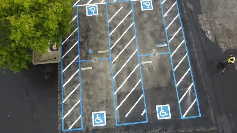 Aerial view of a parking lot with fresh blue ADA handicap stalls and white access aisles in Rohnert Park. Project by We Love Paving in Northern California, CA.
