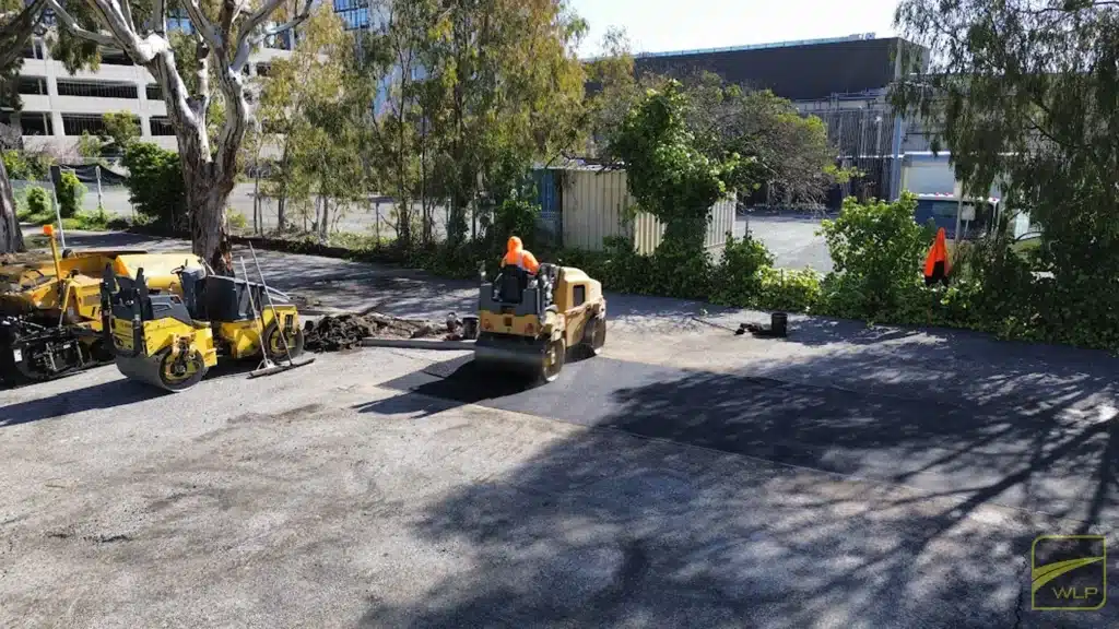 Can You Put Asphalt Over Concrete? Exploring Your Options 2 A yellow steam roller smoothing a fresh layer of black asphalt on a site in Sunnyvale. Project by We Love Paving in Northern California, CA.