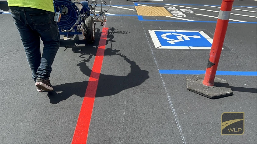 Ebooks 1 A worker painting a solid red fire lane line next to ADA-compliant handicap parking spaces. Project by We Love Paving in Northern California, CA.