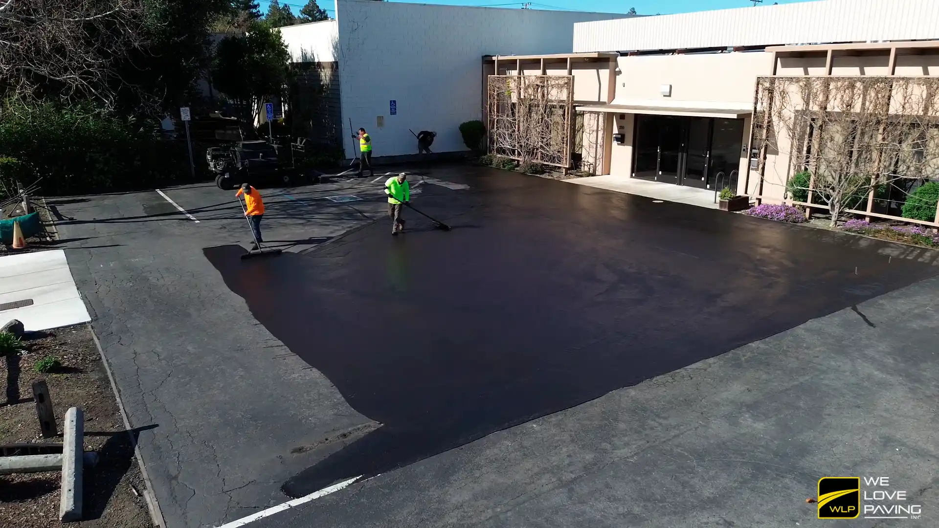 Asphalt Overlay California 2 Workers sealcoating a parking lot In California