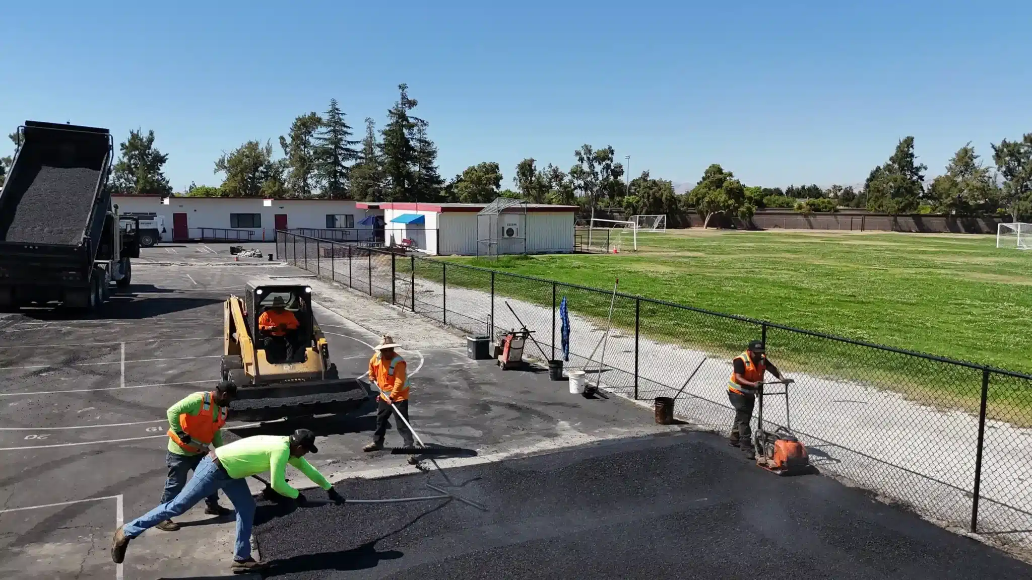 Workers applying hot mix asphalt in school playground in San Francisco