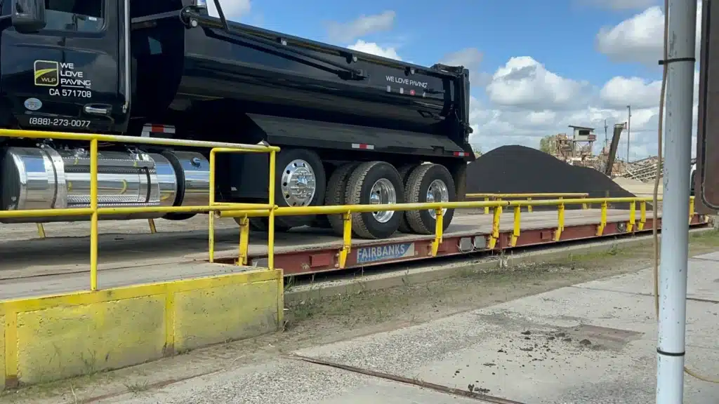 Resort Driveway Maintenance 2 Paving truck on a Fairbanks industrial scale for material weighing.