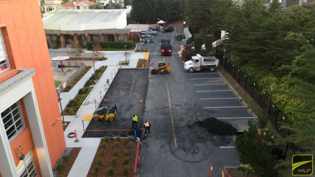 Multi-family Housing Pavement Services 1 Ground-level view of an active asphalt paving construction site with machinery.