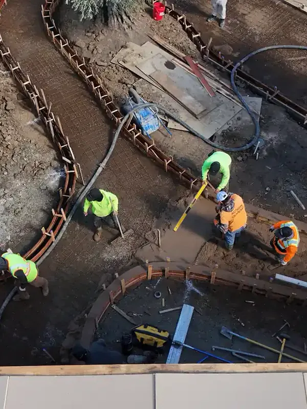 Crew forming and finishing new concrete curbs, seen from above