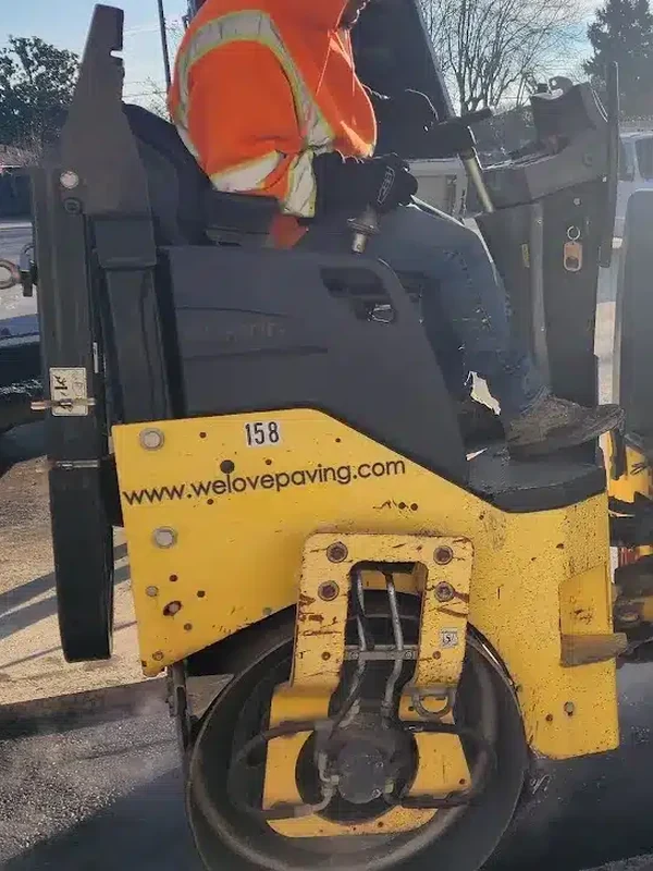 Videos 2 Paving crew member operating a roller to compact new asphalt